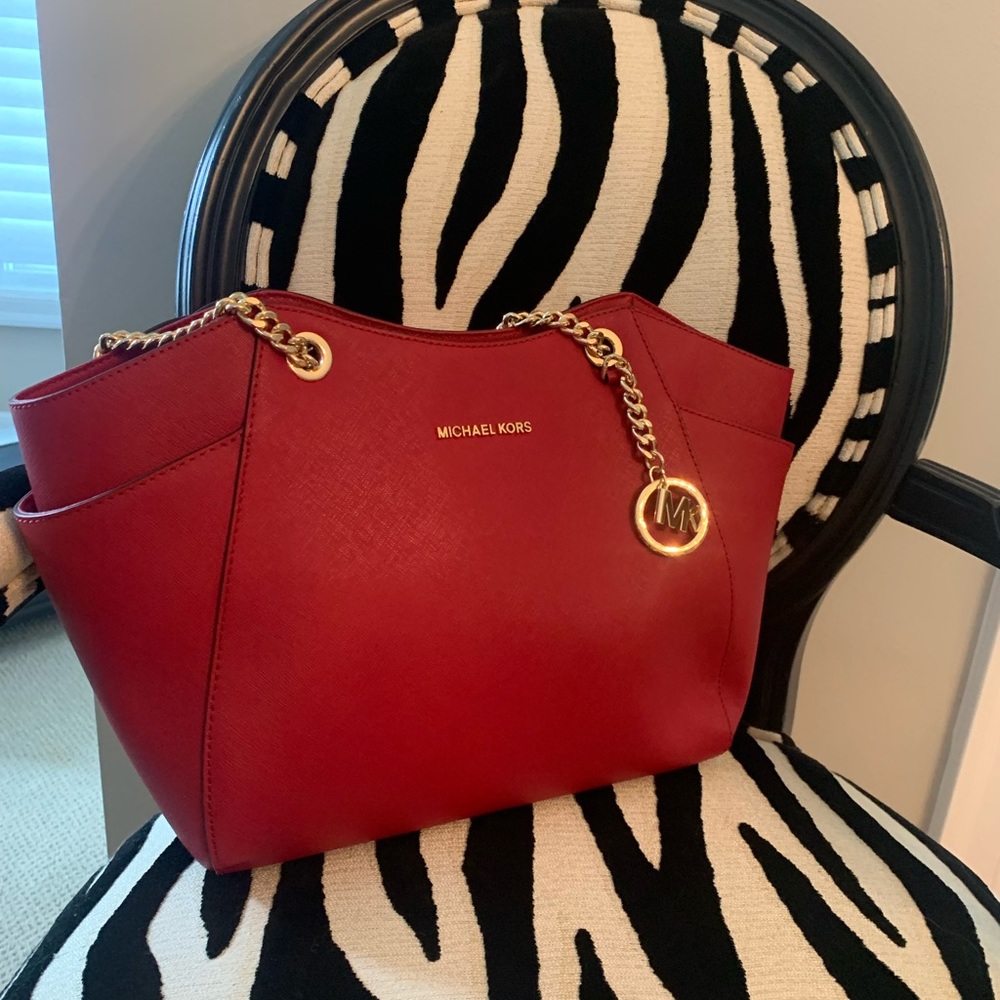 Michael Kors red purse with gold chain straps.